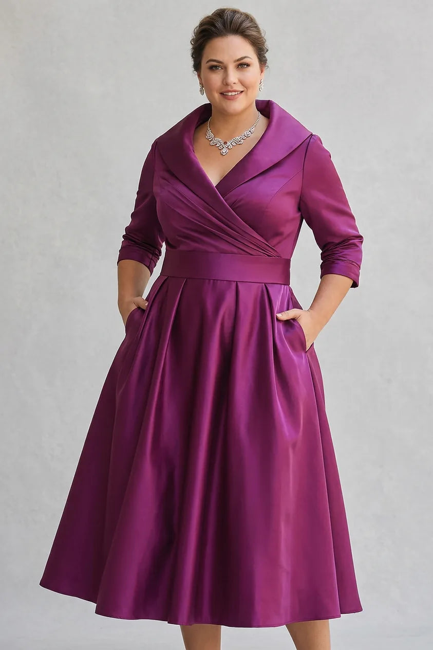 Front view of the wrap midi dress in vivid magenta purple satin, showing both hands tucked into the side pockets and the pleated skirt.
