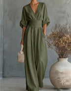 Close view of the wrap neckline and gathered waist detail on the burgundy jumpsuit