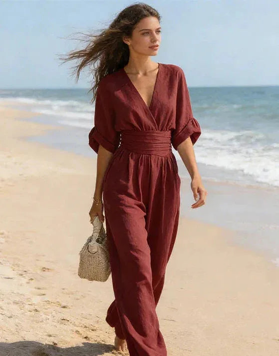 Burgundy wrap jumpsuit with three-quarter puff sleeves worn at an outdoor café table