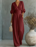 Close-up of the burgundy jumpsuit's V neckline and sleeve detail in warm afternoon light