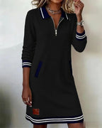 Beige polo dress close-up showing zipped polo collar, ribbed striped cuffs and leather-look patch
