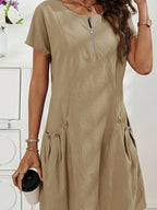Khaki midi dress detail showing the short raglan sleeves, round zip neckline and structured seam lines down the bodice