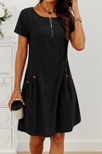 Black midi dress worn with a round pendant necklace, displaying the zip neckline and tonal button pocket detail